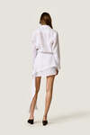 White loose dress with an asymmetric cut and flowing side detail